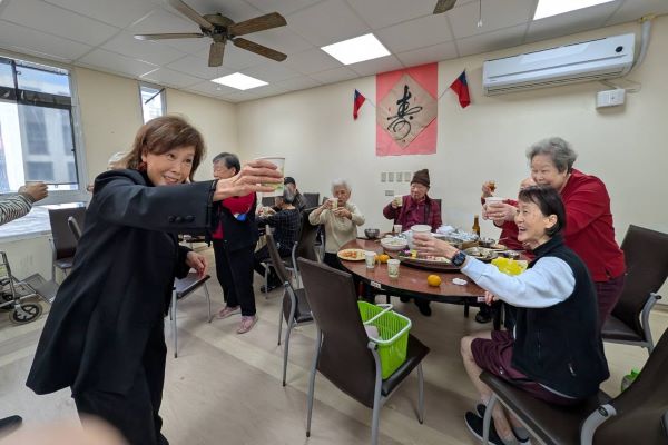 《圖說》陳桂美主任向共享團圓飯長輩們舉杯互道祝福。〈板橋榮家提供〉