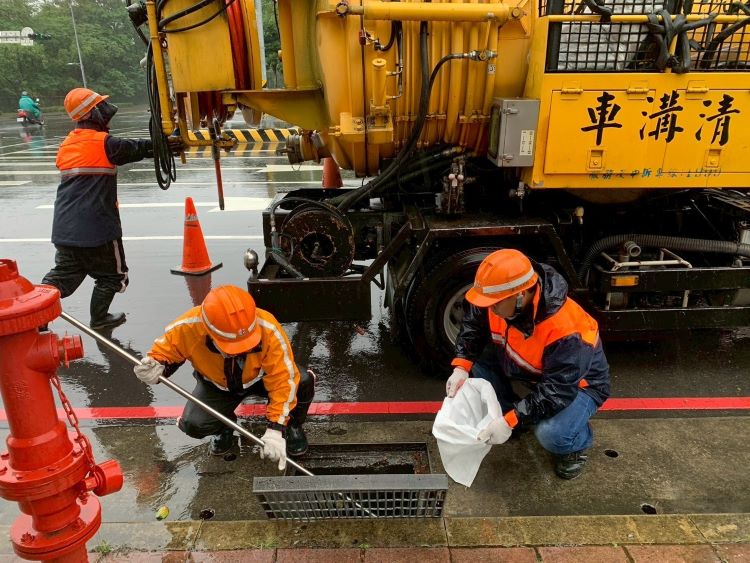 《圖說》清潔隊員清理路邊水溝，保持環境乾淨與排水暢通。〈環保局提供〉