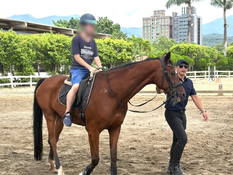 《圖說》騎警隊員為星兒牽乘馬匹實際體驗馬術。〈市警局提供〉